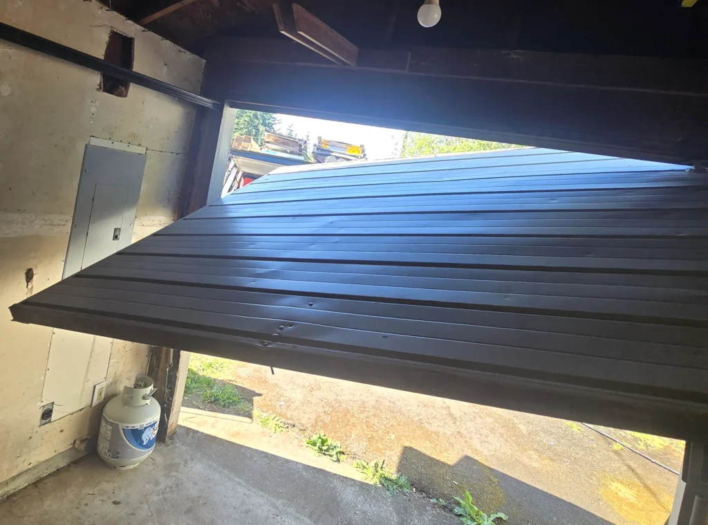 Garage door partially open, damaged.