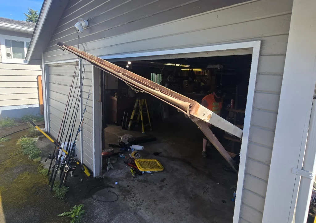 Garage door partially detached, fishing rods visible.