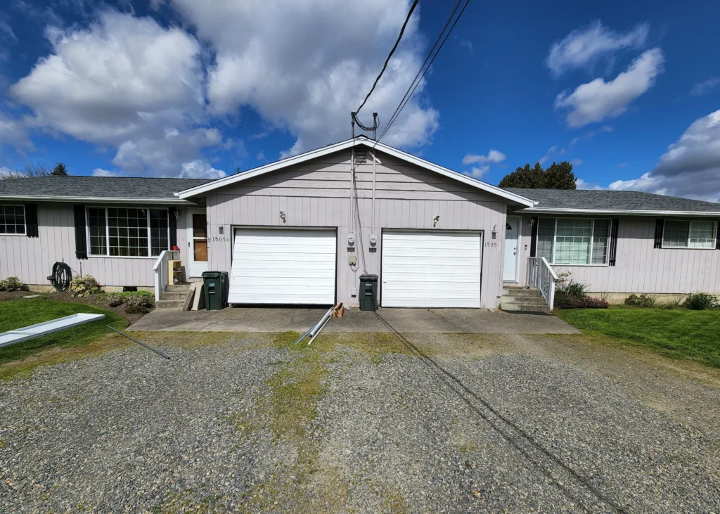 Duplex with garages and cloudy sky